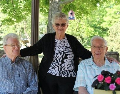 A woman and two men smiling.