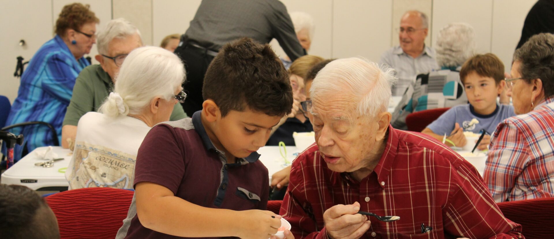 A young boy working with an elderly man.