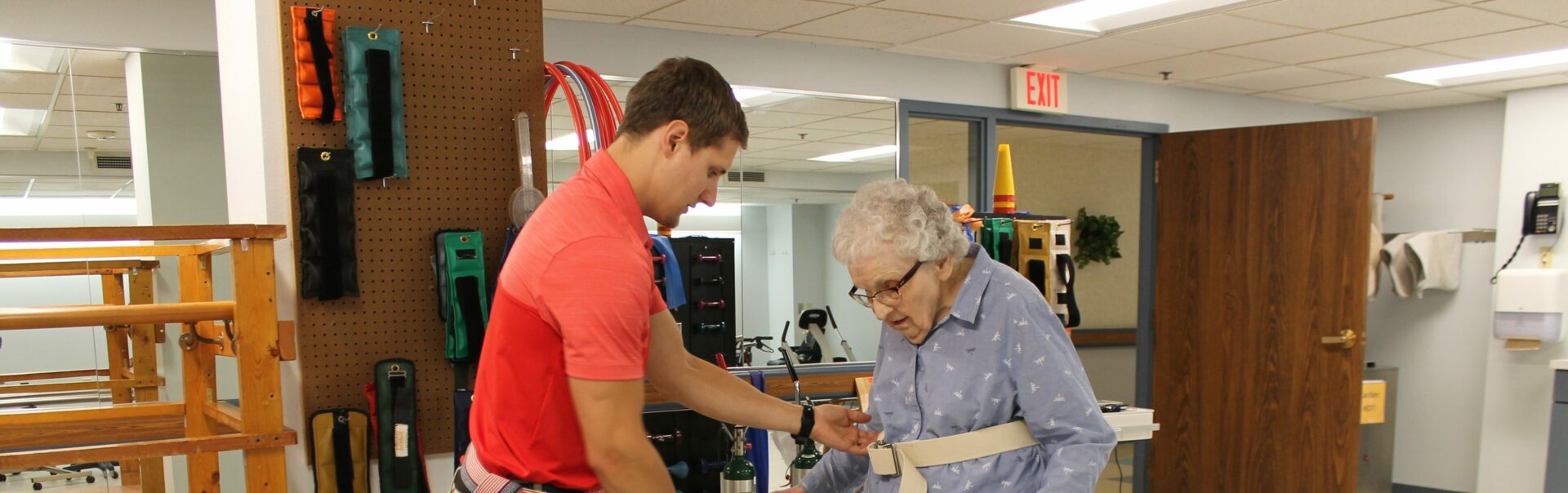 A physical therapist helping an elderly lady walk.