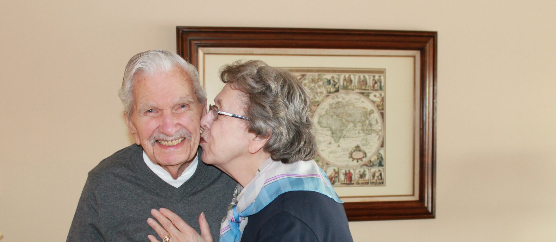 A lady kissing her husband on the cheek.