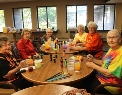 VMP West Allis Senior Community Club senior ladies smiling at the camera painting pumpkins